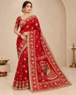 Red festive saree with mirror work, decorative border, and traditional Karwachauth-style motifs.